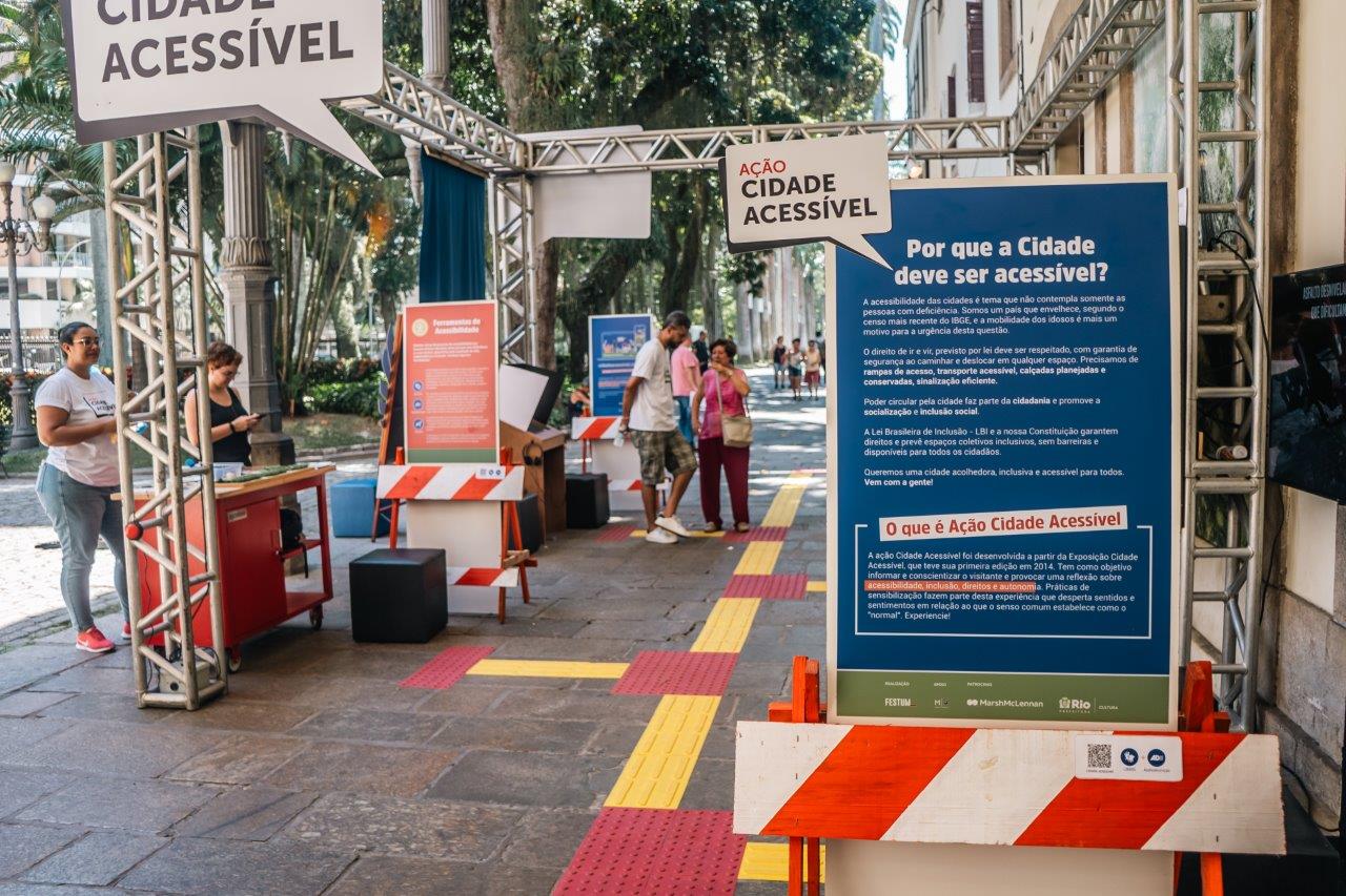 Entrada do circuito da Ação Cidade Acessível, local externo com banners e um grande painel informativo com título